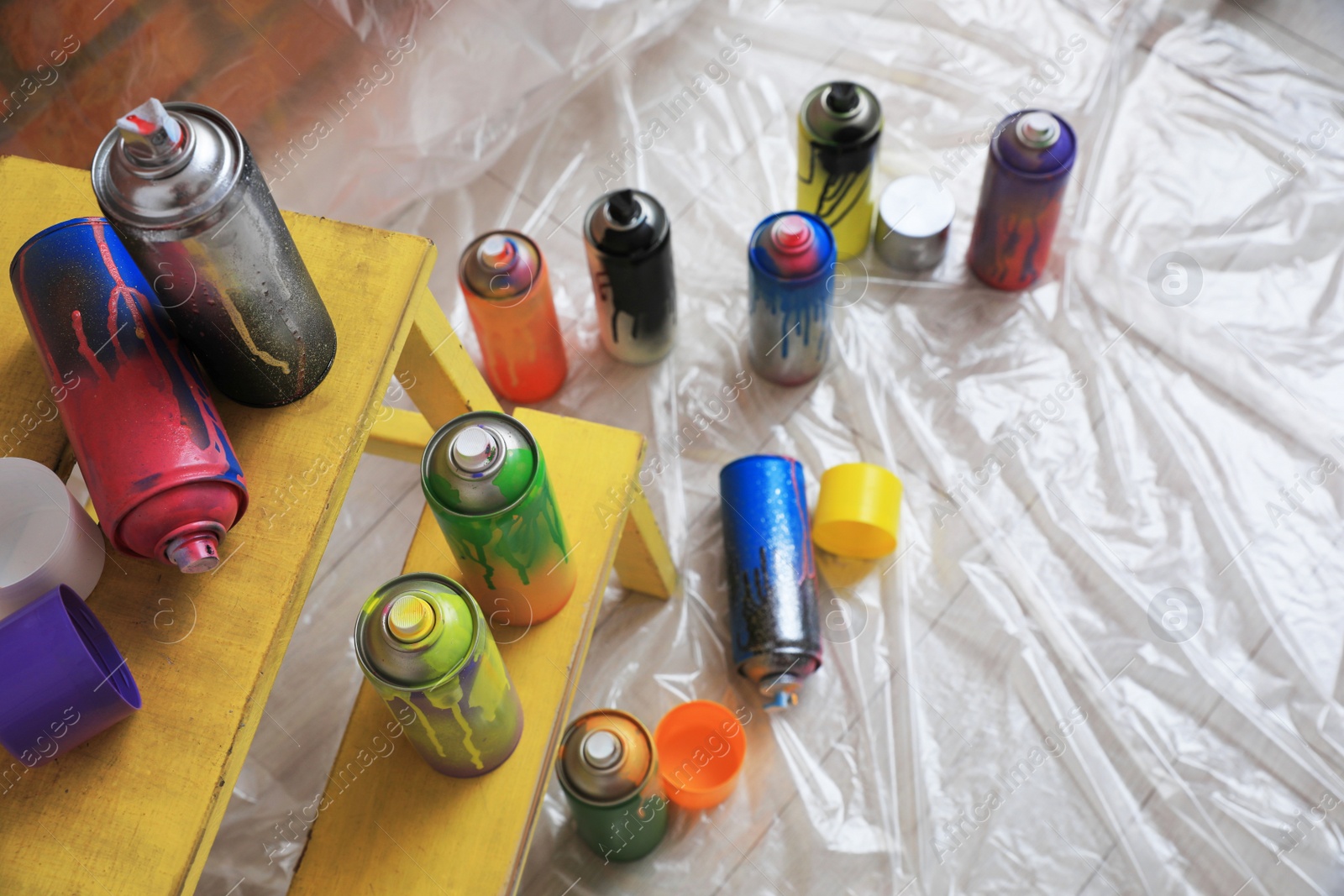 Photo of Used cans of spray paints indoors, above view. Graffiti supplies