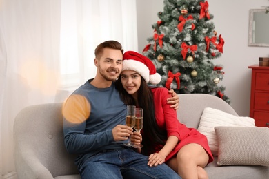 Photo of Young couple with glasses of champagne at home. Christmas celebration