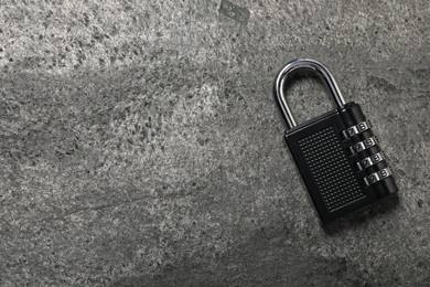 Photo of One steel combination padlock on grey table, top view. Space for text
