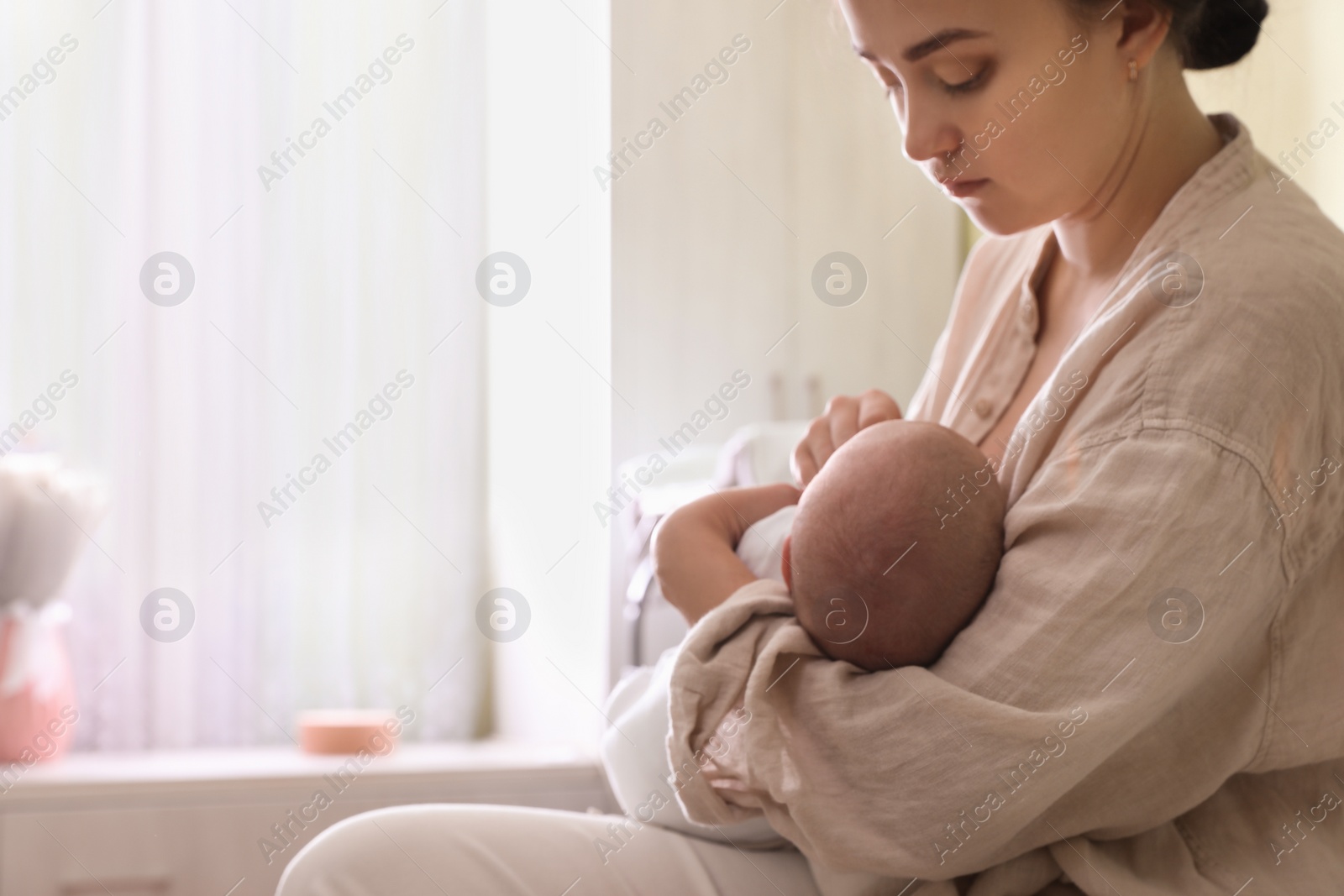 Photo of Mother holding her sleeping baby at home, closeup