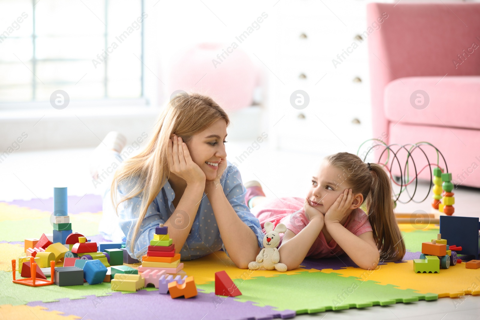 Photo of Mother playing with her child at home