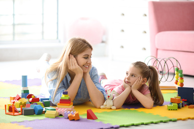 Photo of Mother playing with her child at home