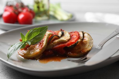 Delicious ratatouille served with basil on table, closeup
