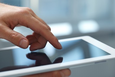 Closeup view of man using new tablet indoors