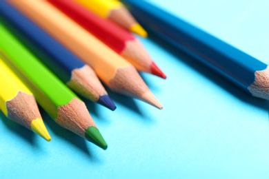 Photo of Colorful pencils on light blue background, closeup