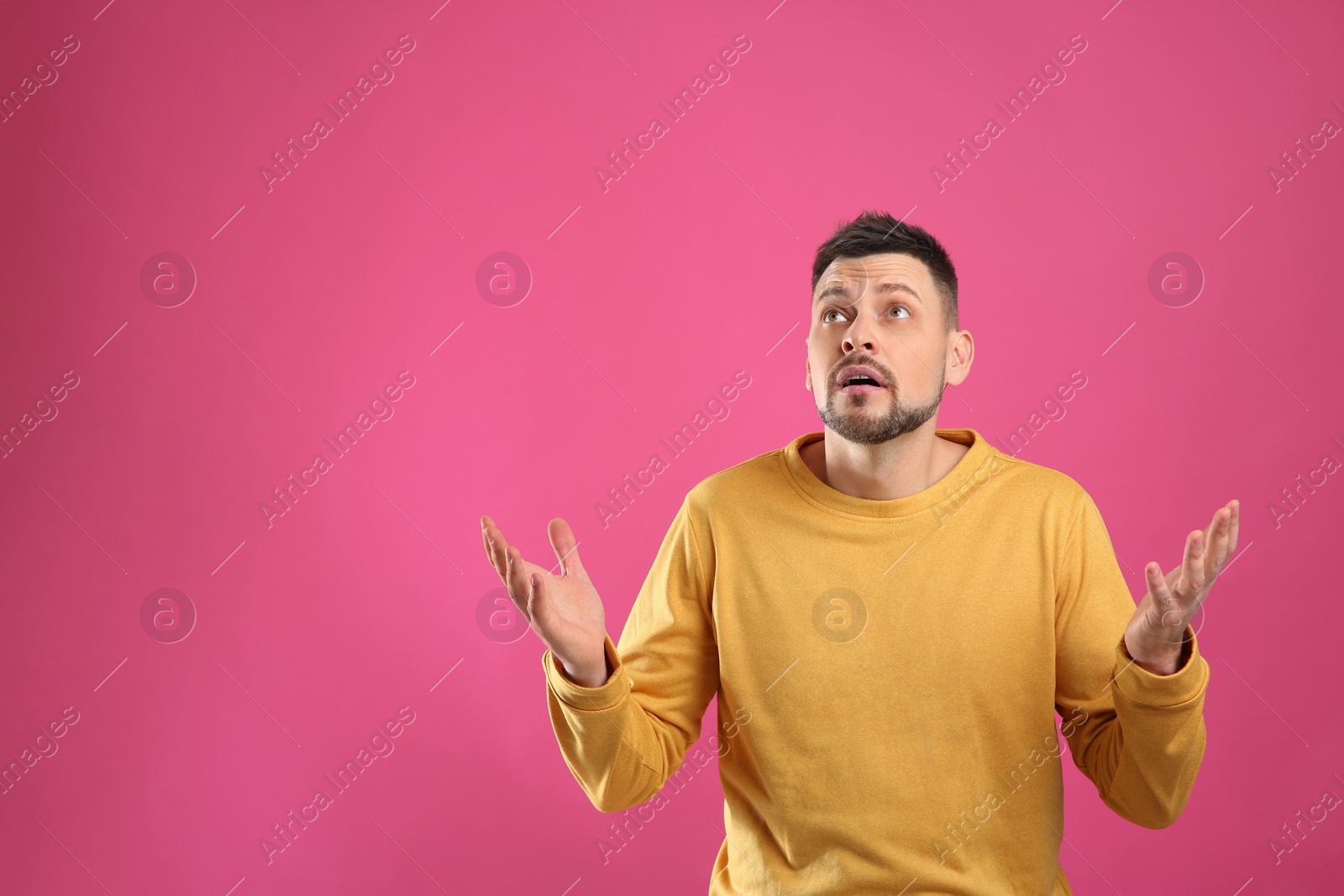 Photo of Emotional man on pink background, space for text