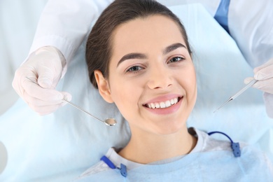 Dentist examining patient's teeth in modern clinic