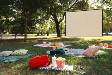 Empty open air cinema with blankets, pillows and popcorn. Space for text