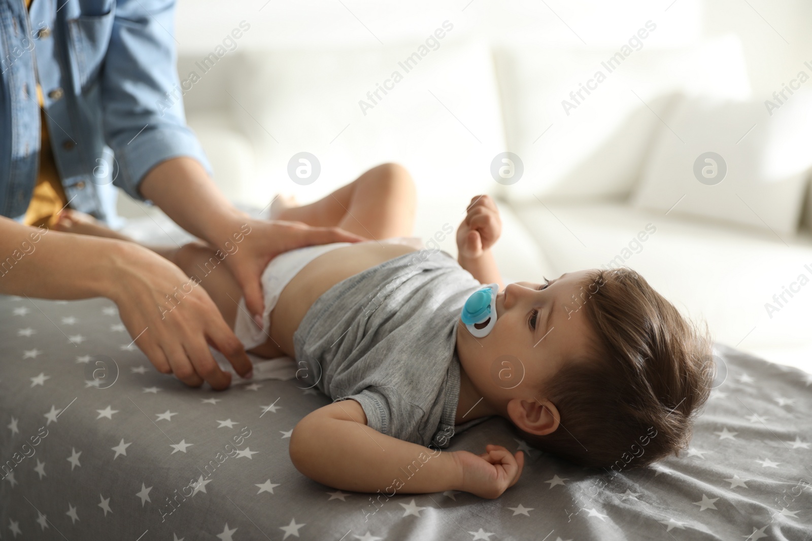 Photo of Mother changing baby's diaper on table at home