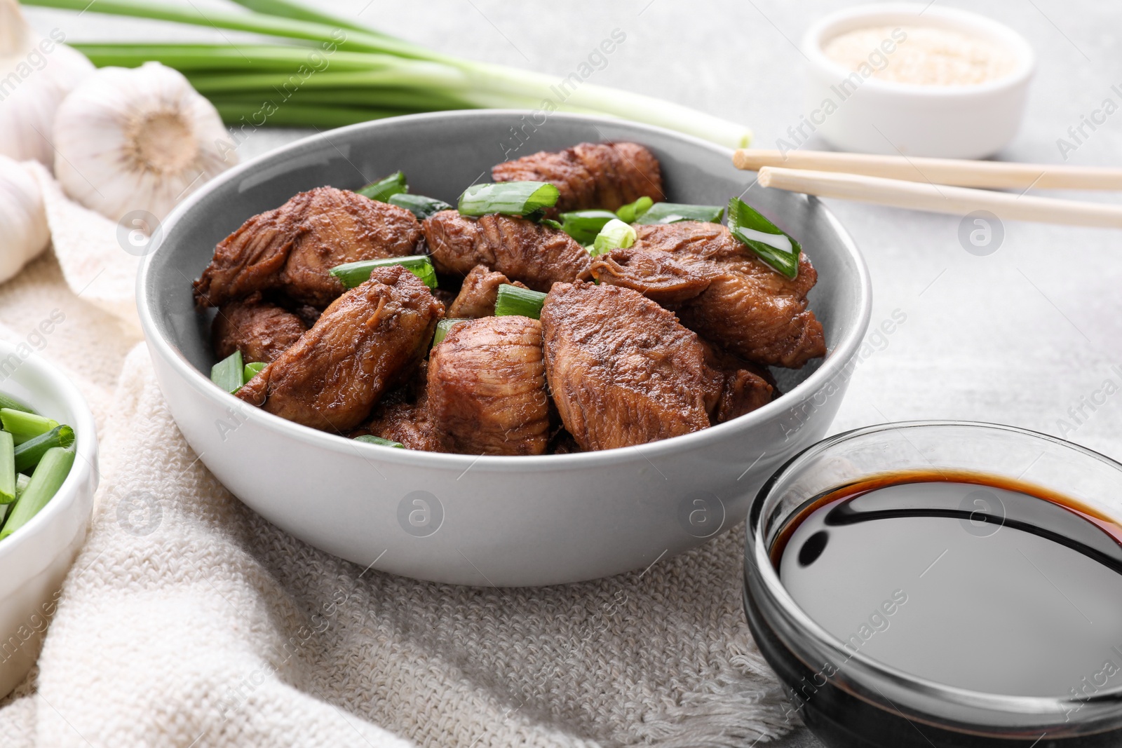 Photo of Tasty soy sauce and roasted meat on table, closeup