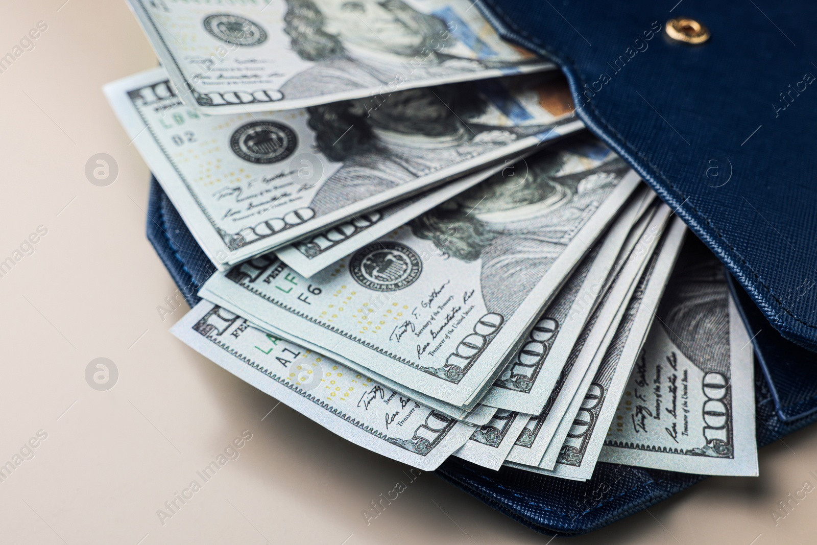 Photo of Dollar banknotes in wallet on wooden table, closeup. Money exchange