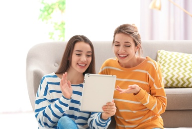 Photo of Women using tablet for video chat in living room