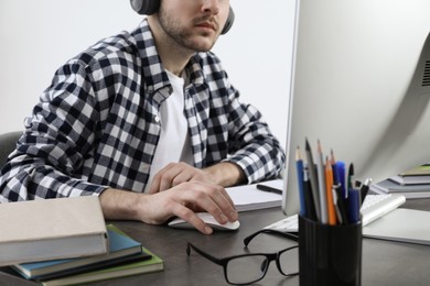 Photo of Young man using modern computer for studying at home, closeup. Distance learning