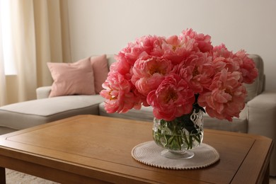 Beautiful pink peonies in vase on table at home, space for text. Interior design