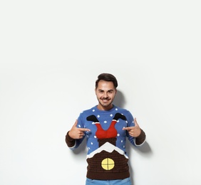 Photo of Young man in Christmas sweater on white background