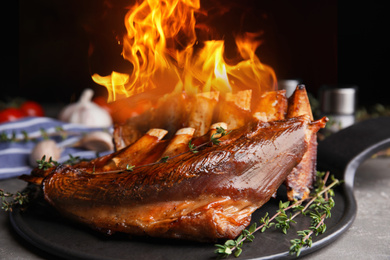 Delicious roasted ribs with flame on table