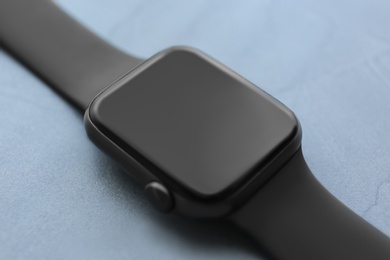 Photo of Stylish smart watch on grey stone table, closeup