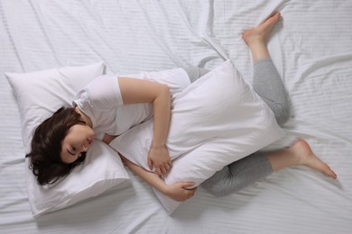 Young woman suffering from insomnia in bed, top view