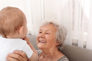 Photo of Happy grandmother with little baby at home