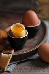 Photo of Soft boiled chicken eggs with toasted bread on wooden table