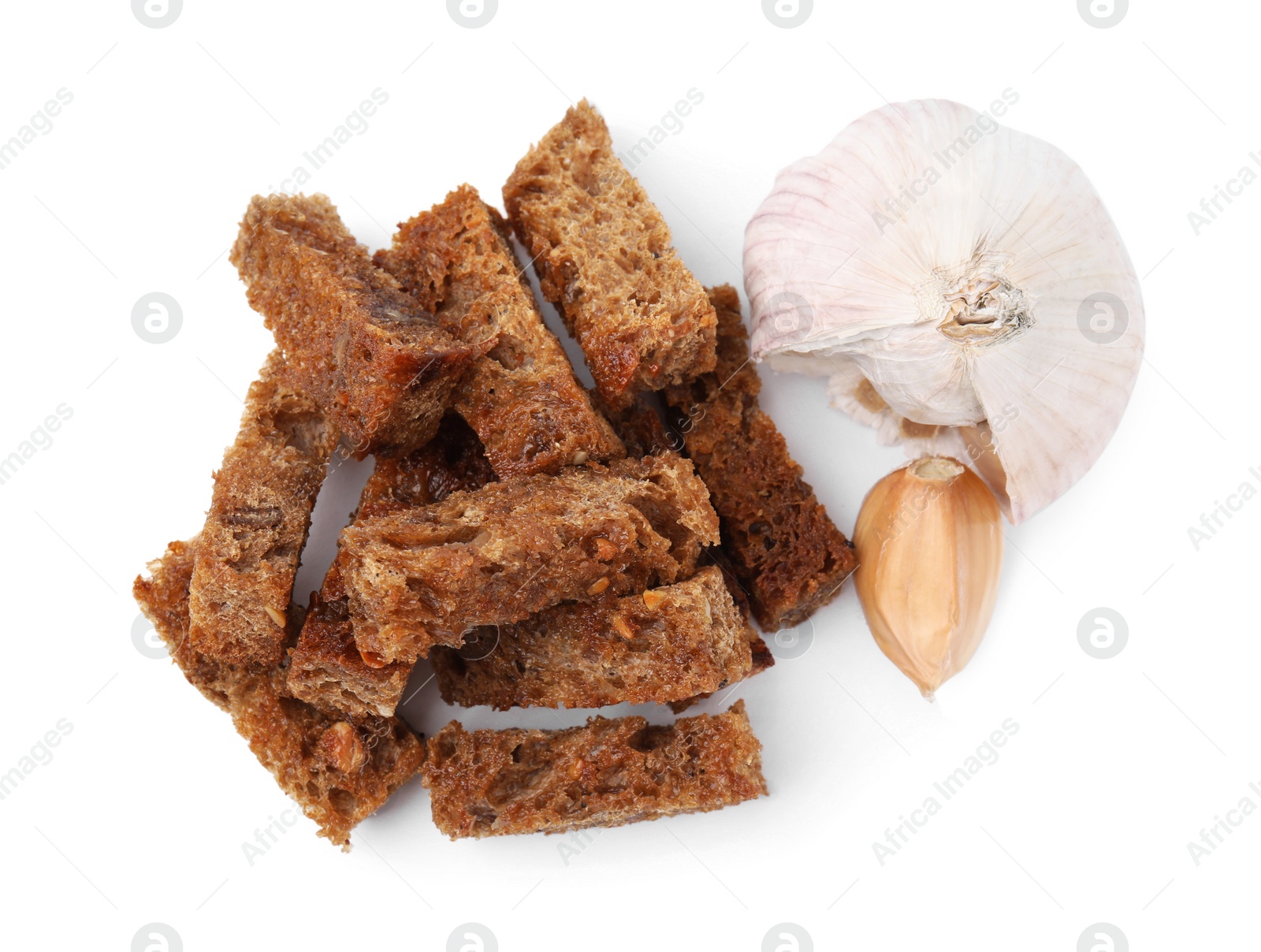 Photo of Delicious crispy rusks and garlic on white background, top view