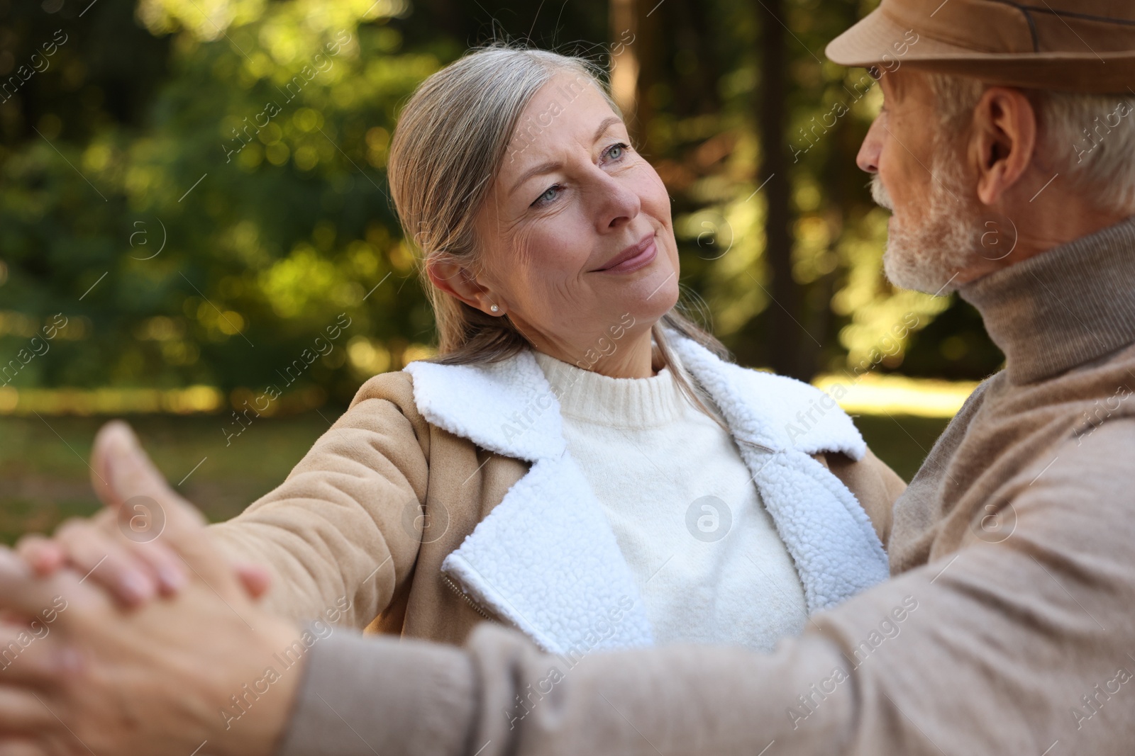 Photo of Affectionate senior couple dancing together outdoors. Romantic date