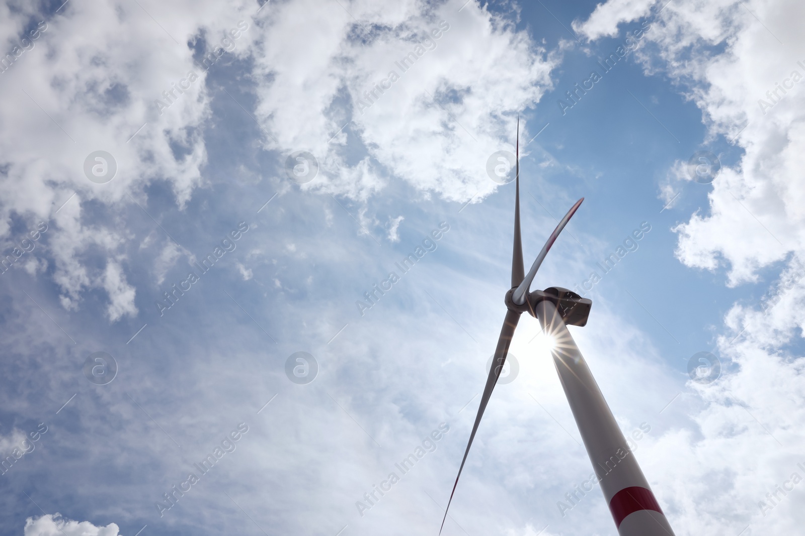 Photo of Modern wind turbine against cloudy sky, low angle view. Alternative energy source