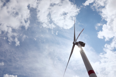 Photo of Modern wind turbine against cloudy sky, low angle view. Alternative energy source