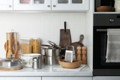 Photo of Different cooking utensils and raw pasta on countertop in kitchen