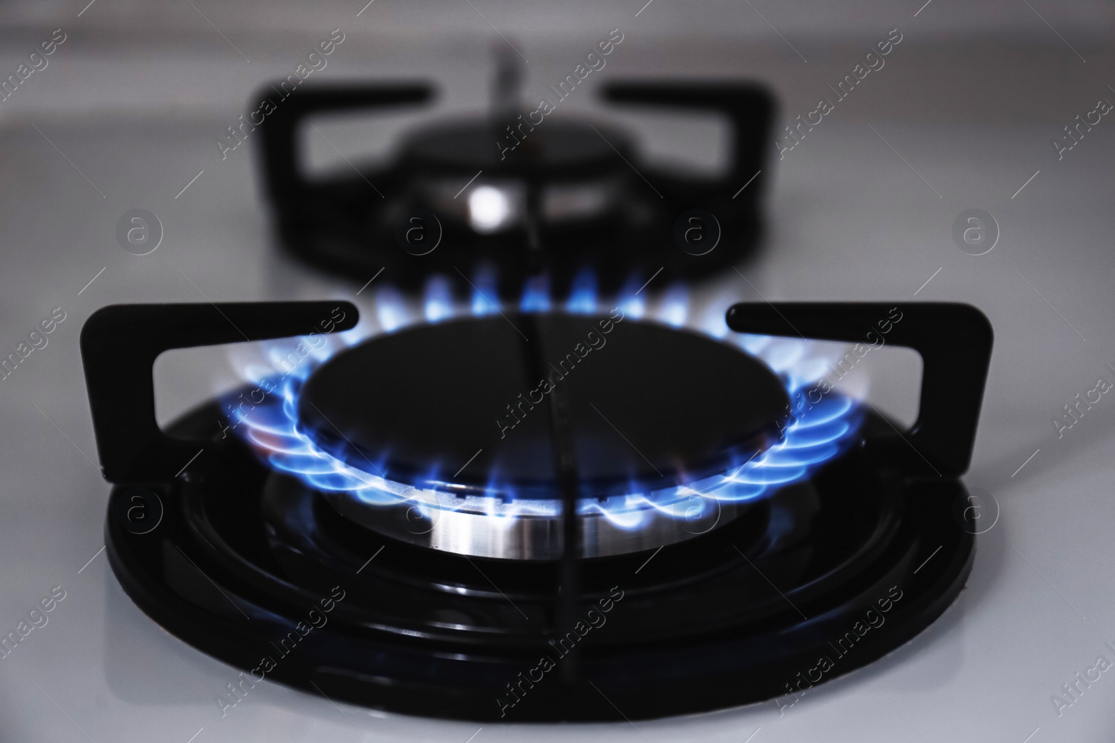 Photo of Modern kitchen stove with burning gas, closeup