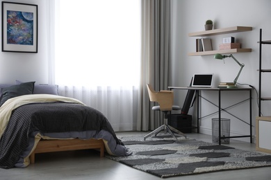 Modern teenager's room interior with workplace and bed