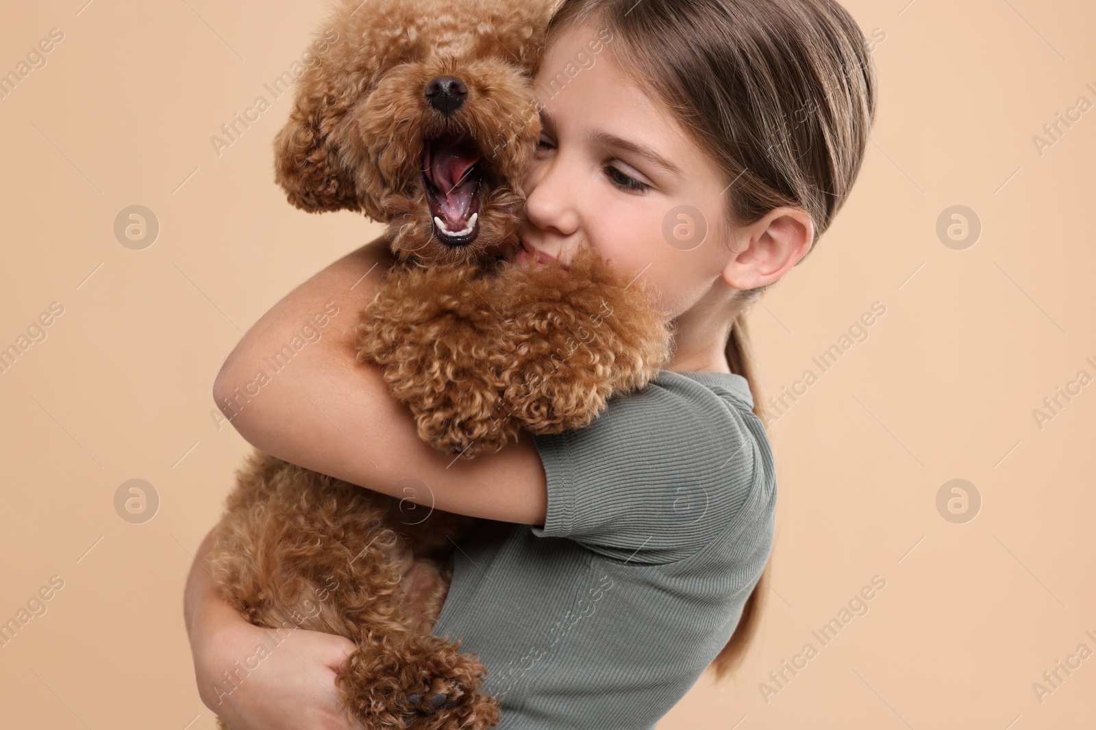 Photo of Little child with cute puppy on beige background. Lovely pet