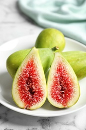 Photo of Plate with fresh ripe figs on marble background