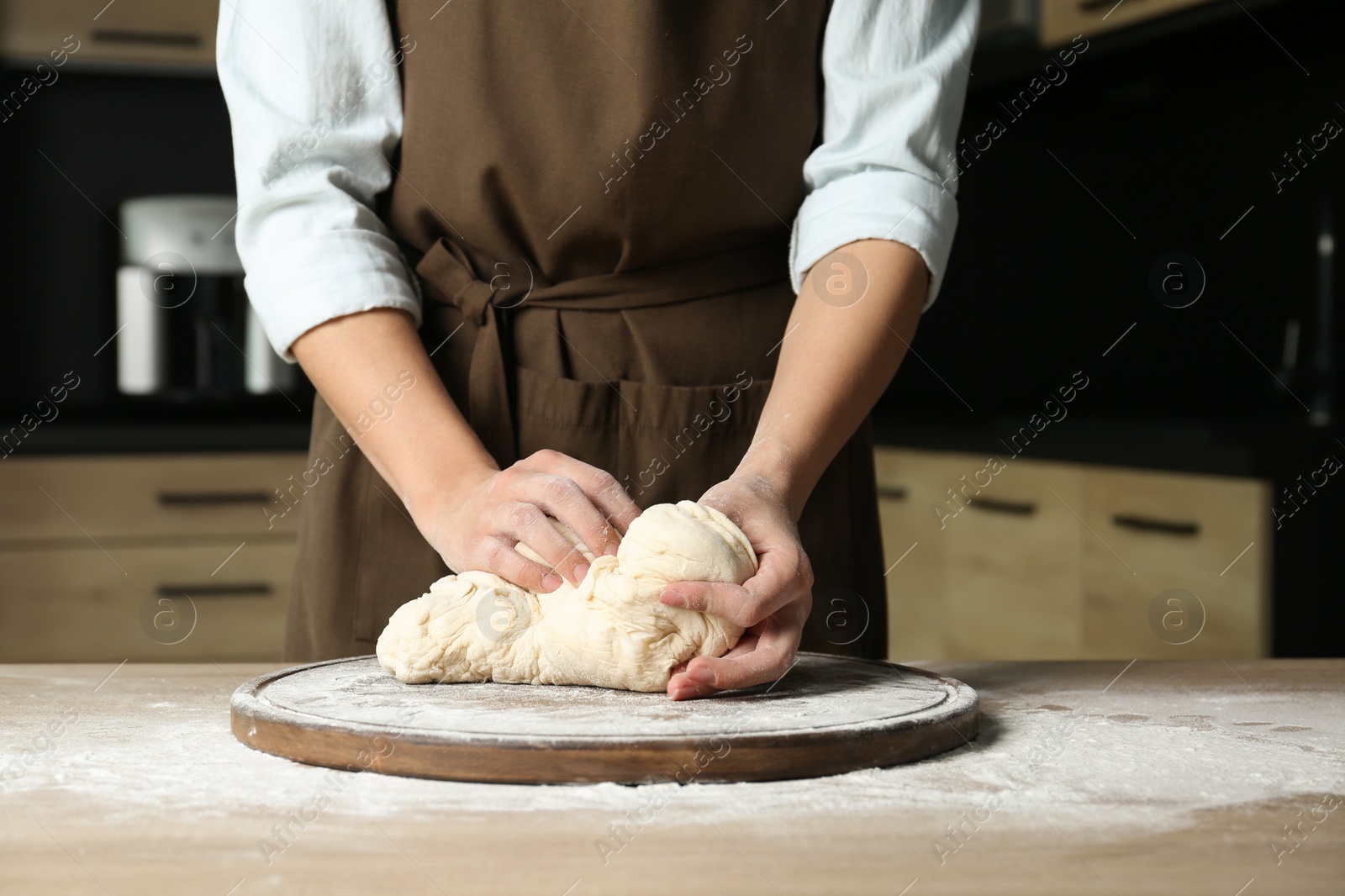 Photo of Female baker preparing bread dough at table, closeup