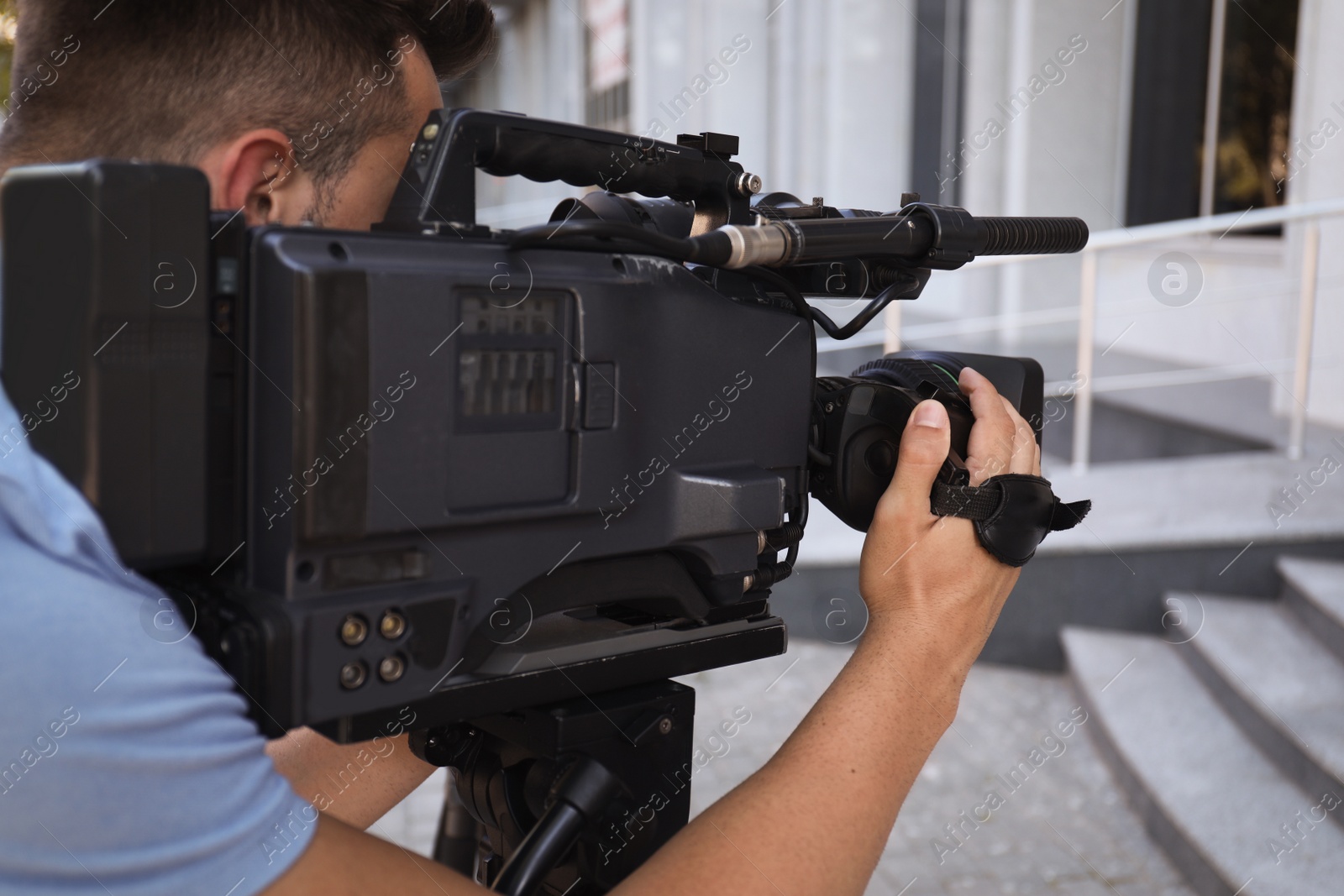 Photo of Professional video camera operator working on city street, closeup