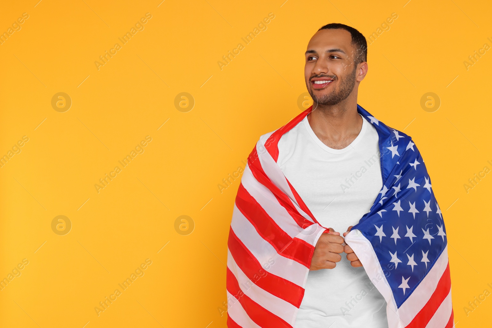 Photo of 4th of July - Independence Day of USA. Happy man with American flag on yellow background, space for text