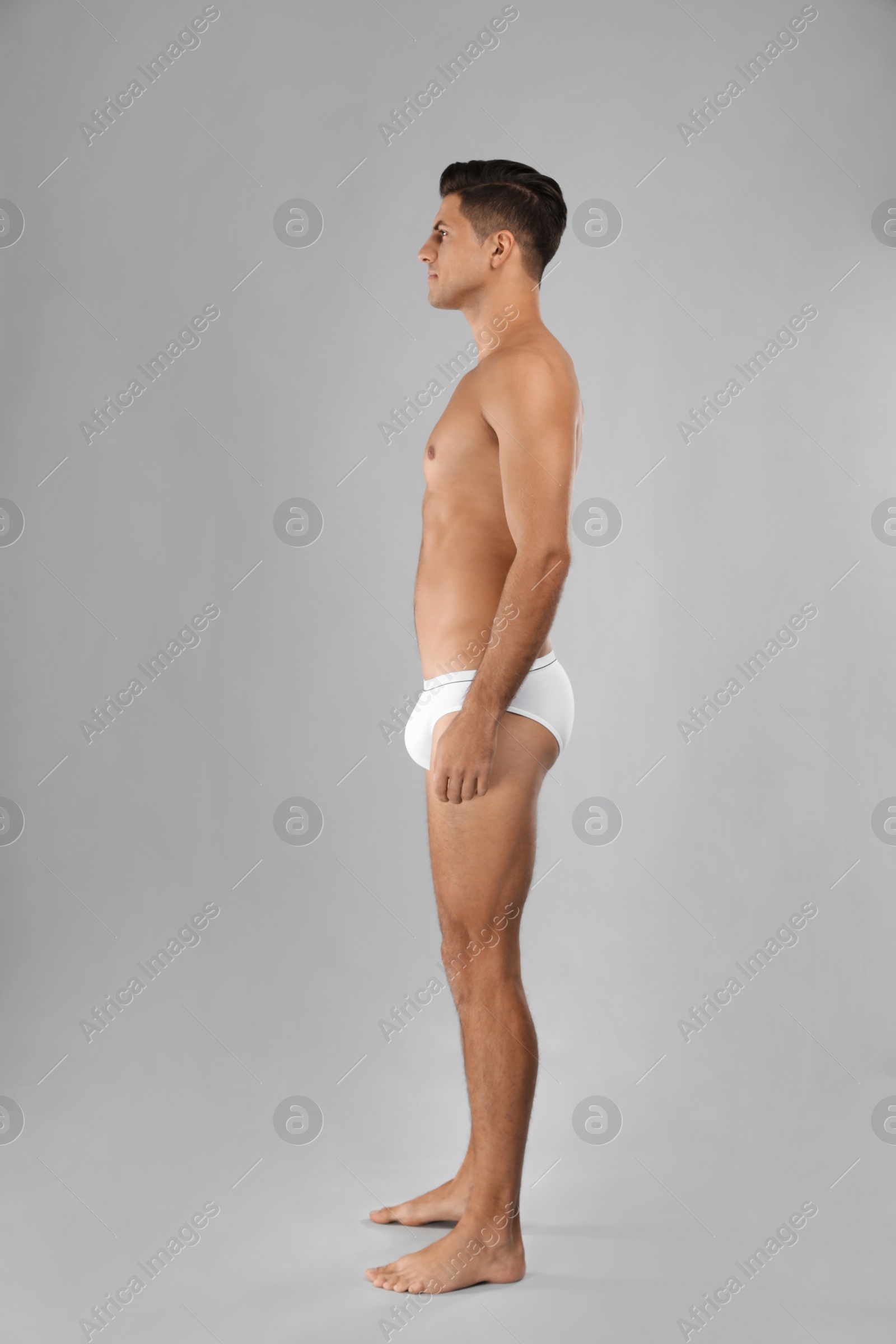 Photo of Handsome man in white underwear on light grey background