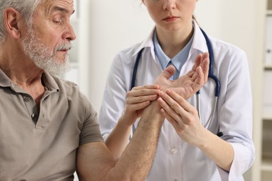 Photo of Arthritis symptoms. Doctor examining patient's hand in hospital