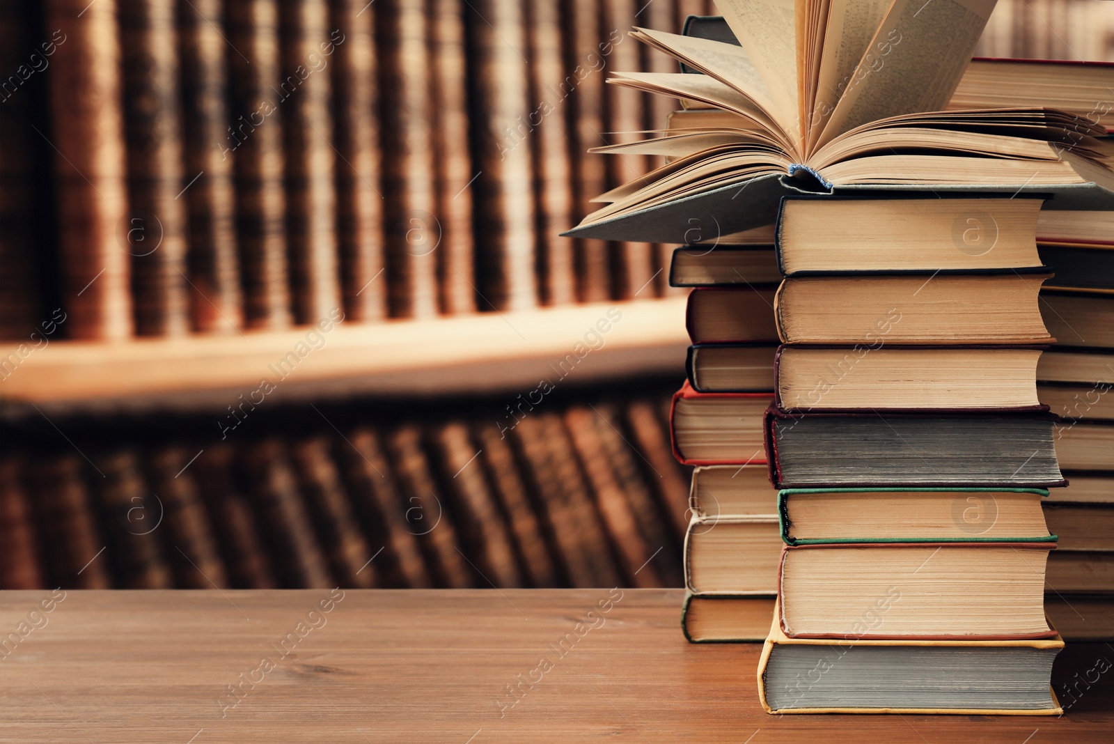 Image of Many books on wooden table in library. Space for text 