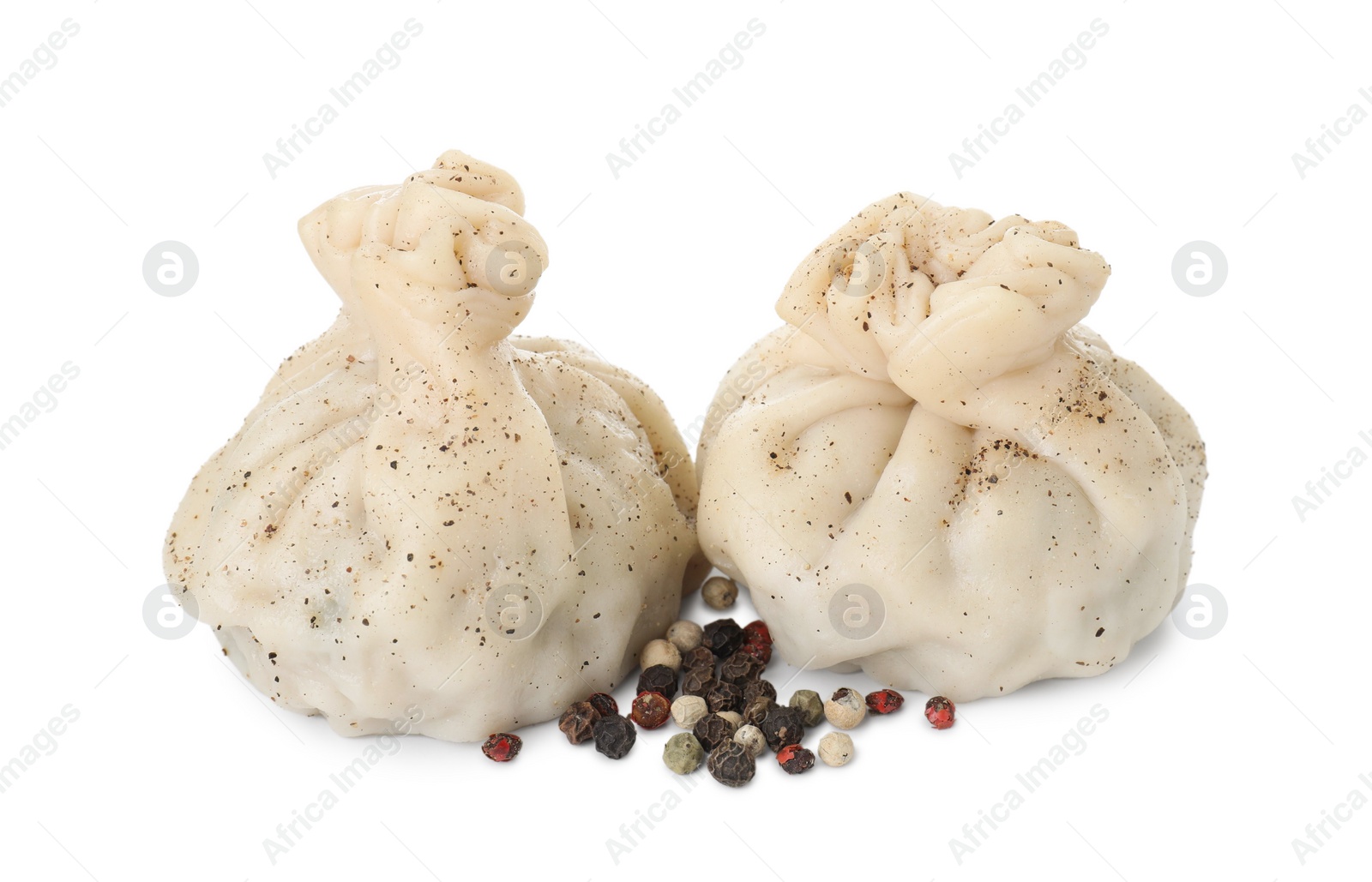 Photo of Two tasty khinkali (dumplings) and spices isolated on white. Georgian cuisine