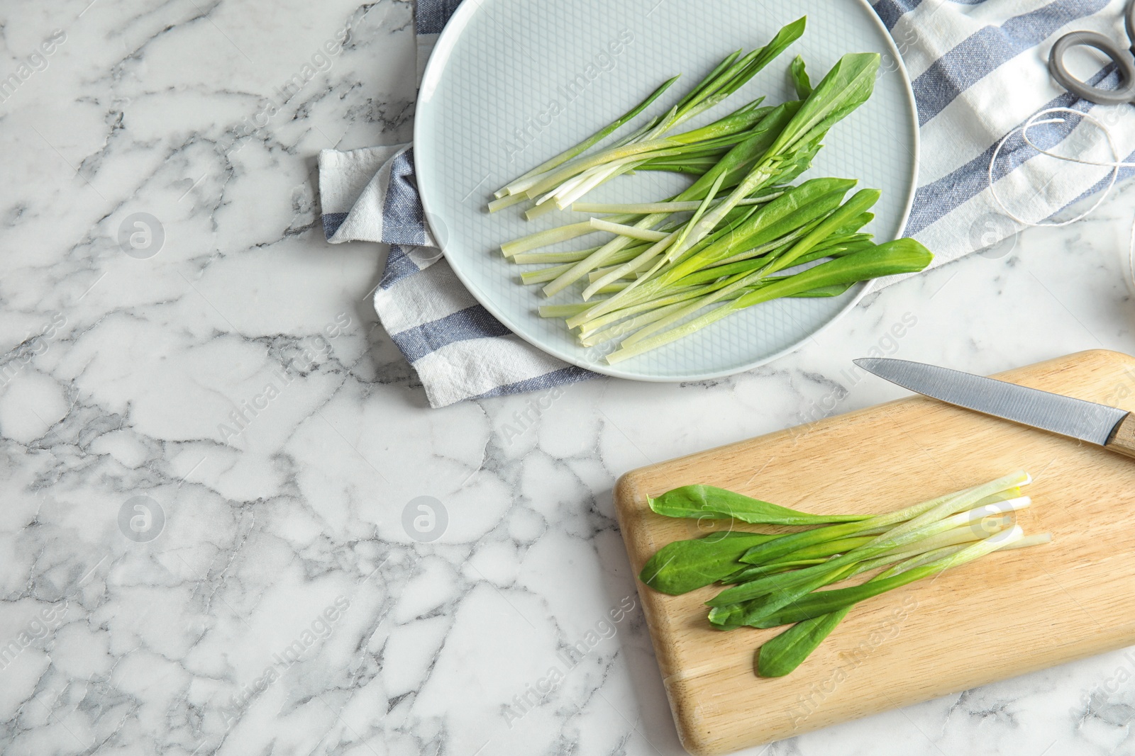 Photo of Flat lay composition with wild garlic or ramson on marble table. Space for text