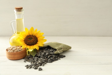 Photo of Composition with sunflower oil on white wooden table, space for text