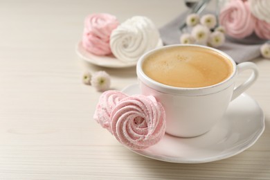 Photo of Delicious pink marshmallows and cup of coffee on wooden table. Space for text