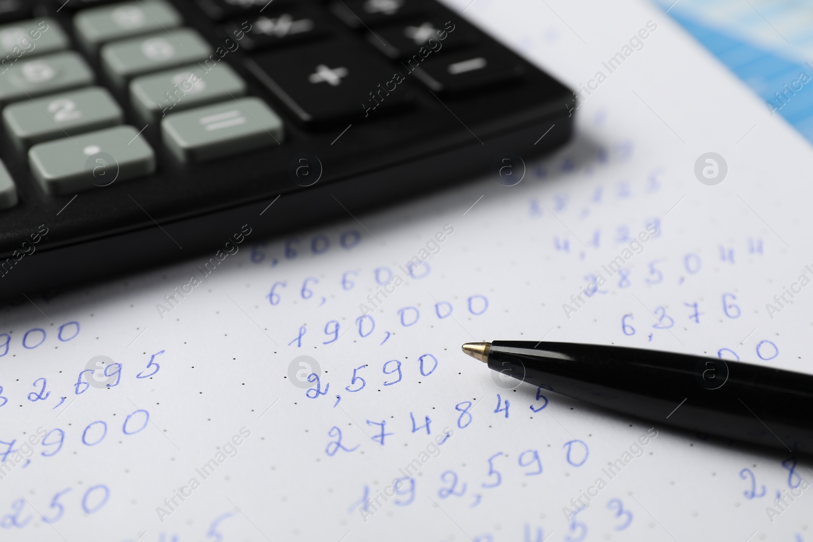 Photo of Calculator and pen on document with data, closeup view