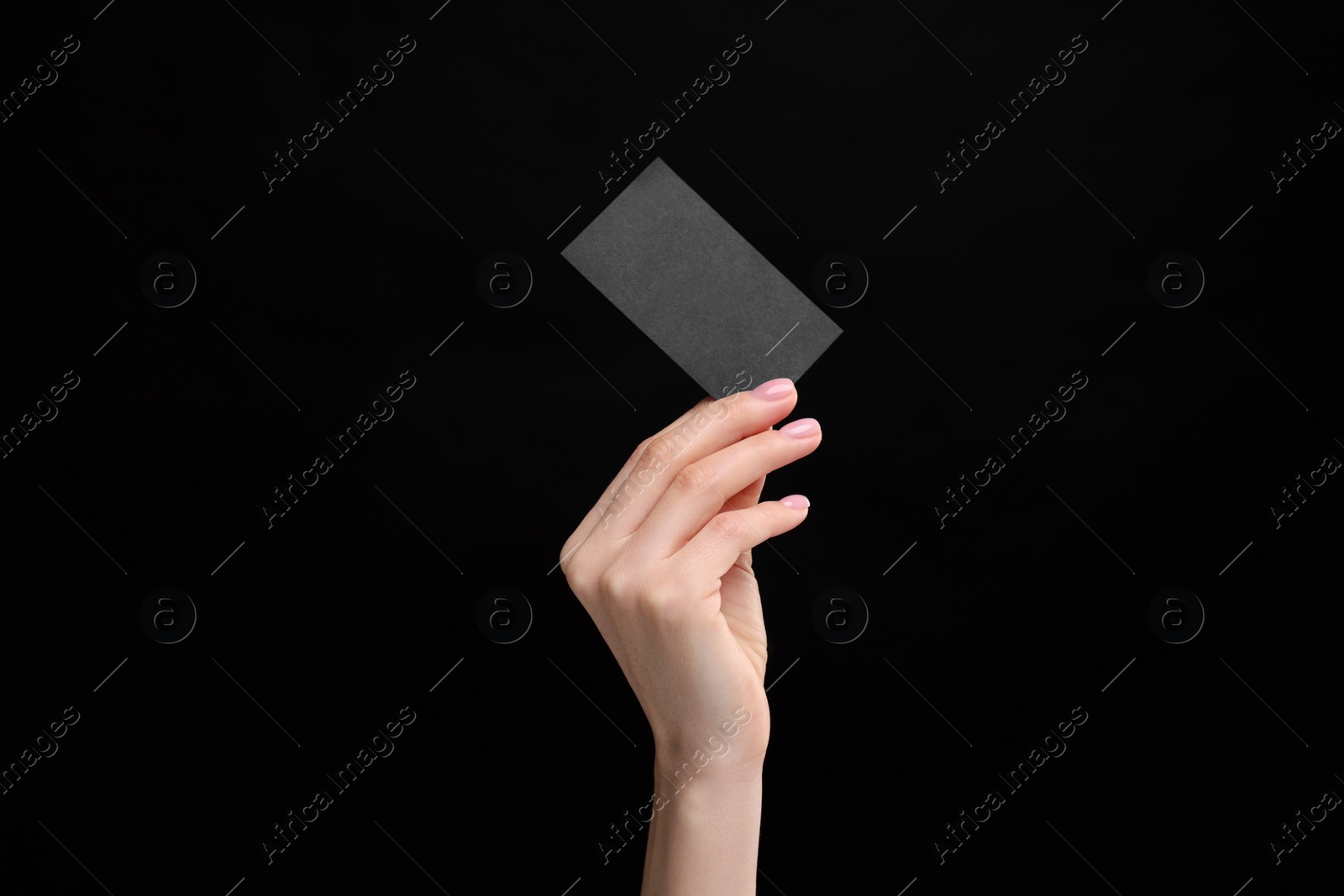 Photo of Woman holding blank business card on black background, closeup. Space for text