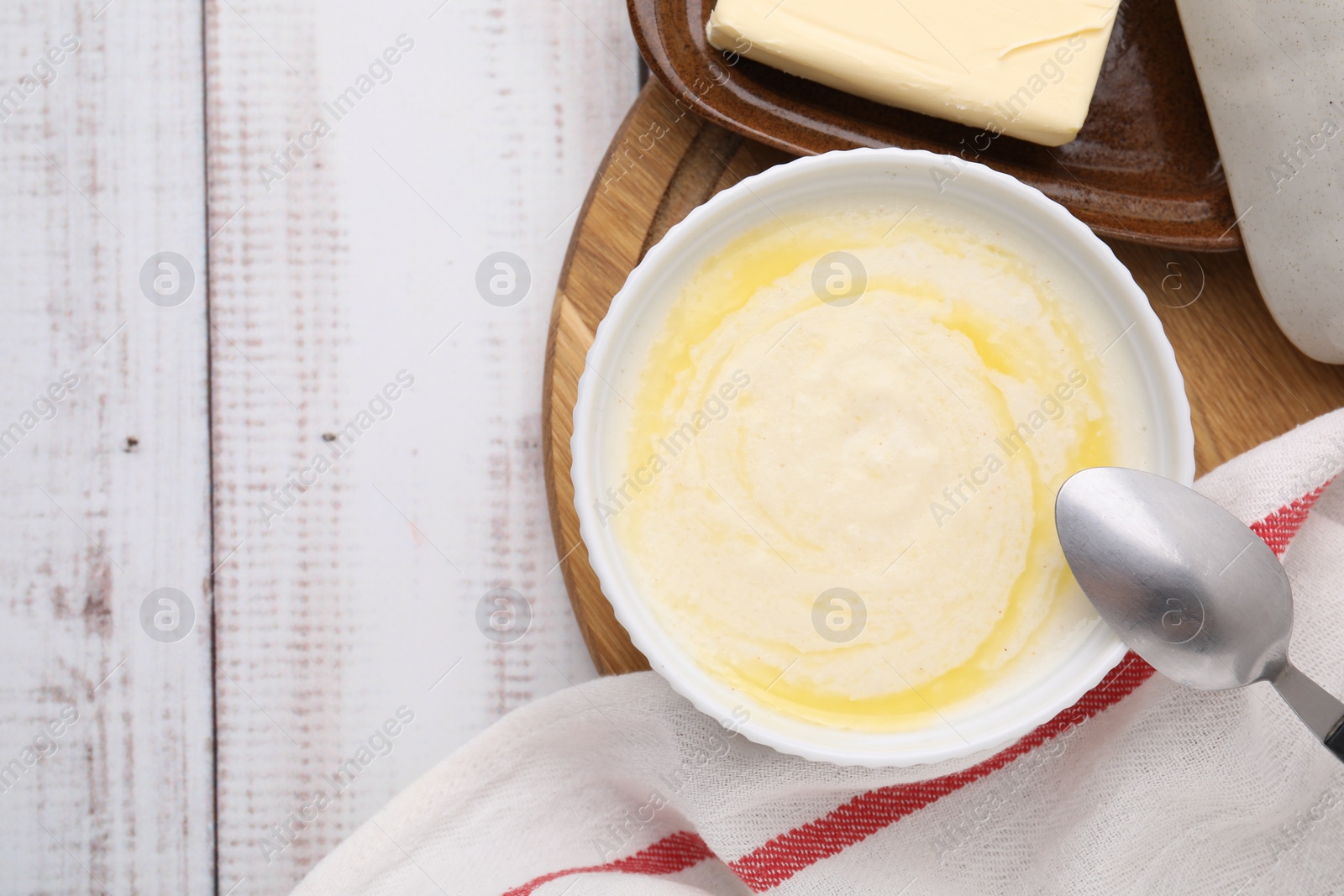 Photo of Bowl of delicious semolina pudding with butter served on table, top view. Space for text