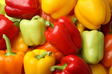 Photo of Fresh ripe colorful bell peppers as background, top view