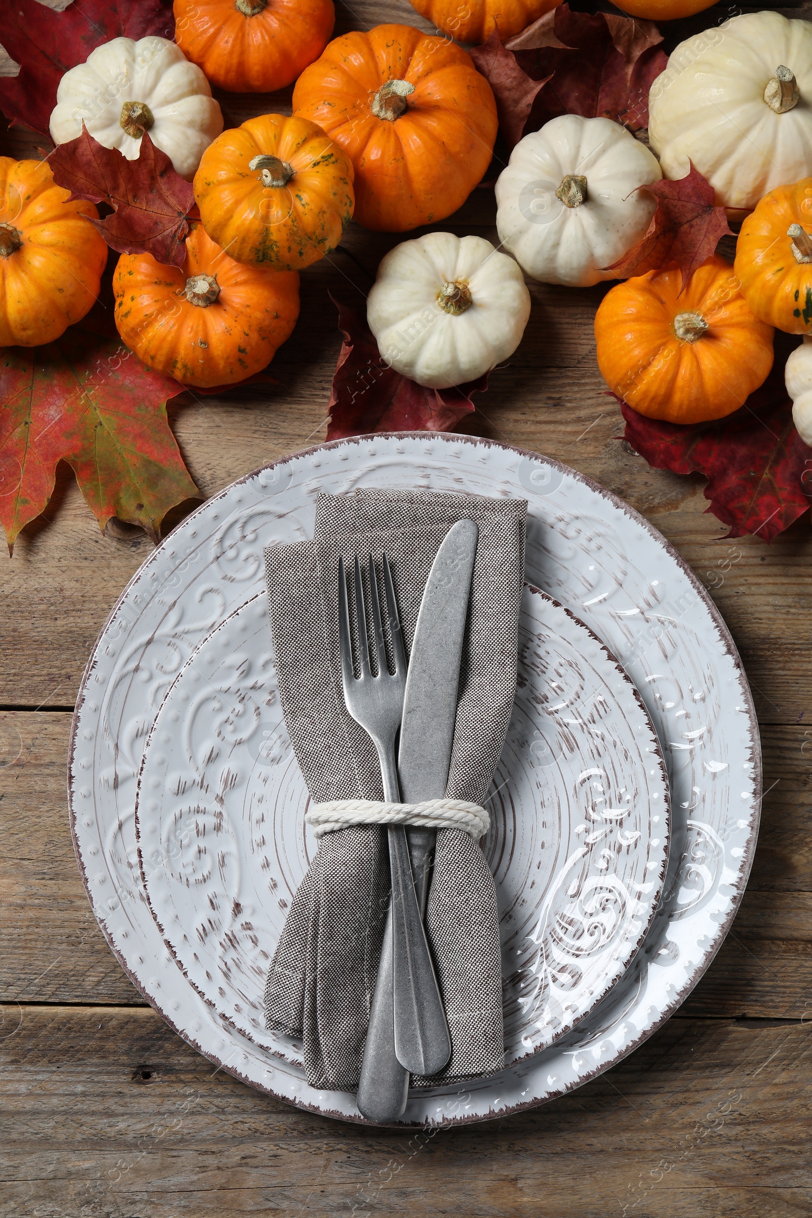 Photo of Happy Thanksgiving day. Beautiful table setting, autumn leaves and pumpkins on wooden background, flat lay