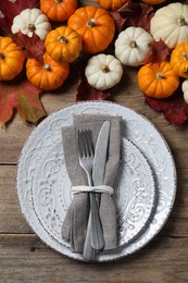 Happy Thanksgiving day. Beautiful table setting, autumn leaves and pumpkins on wooden background, flat lay