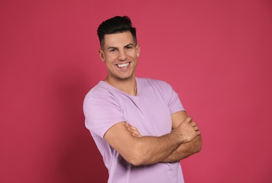 Photo of Handsome man laughing on pink background. Funny joke